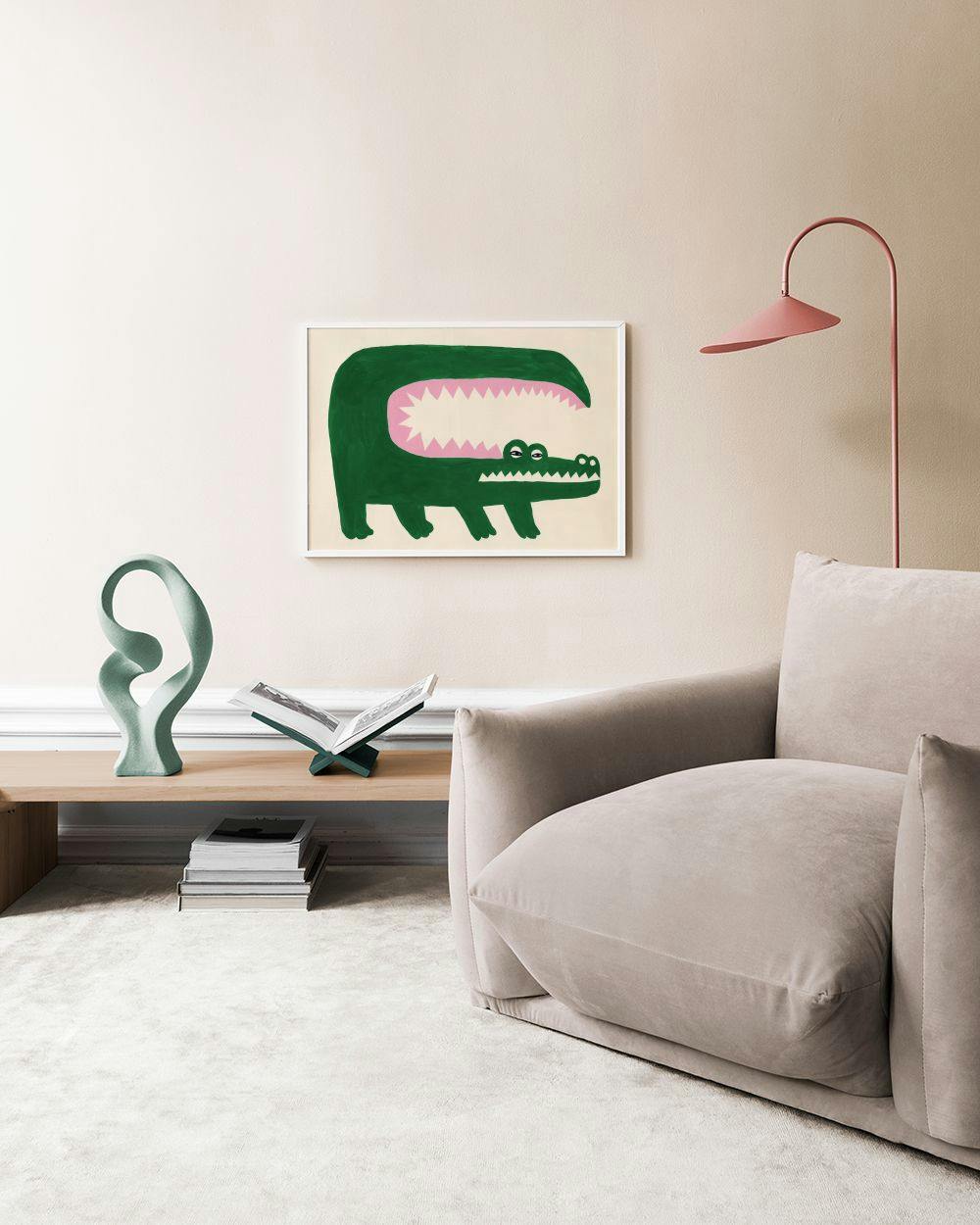 Affiche dun crocodile vert à la gueule rose avec des dents triangulaires, accrochée au-dessus dun canapé beige dans un salon mod