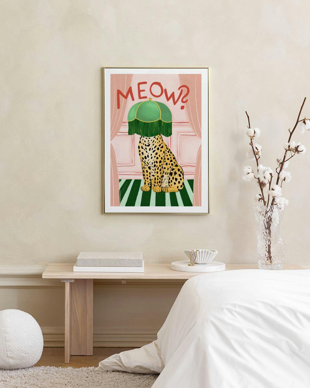 Affiche avec un léopard assis coiffé dun abat-jour vert, texte MEOW? et rideaux roses, accrochée dans une chambre scandinave.