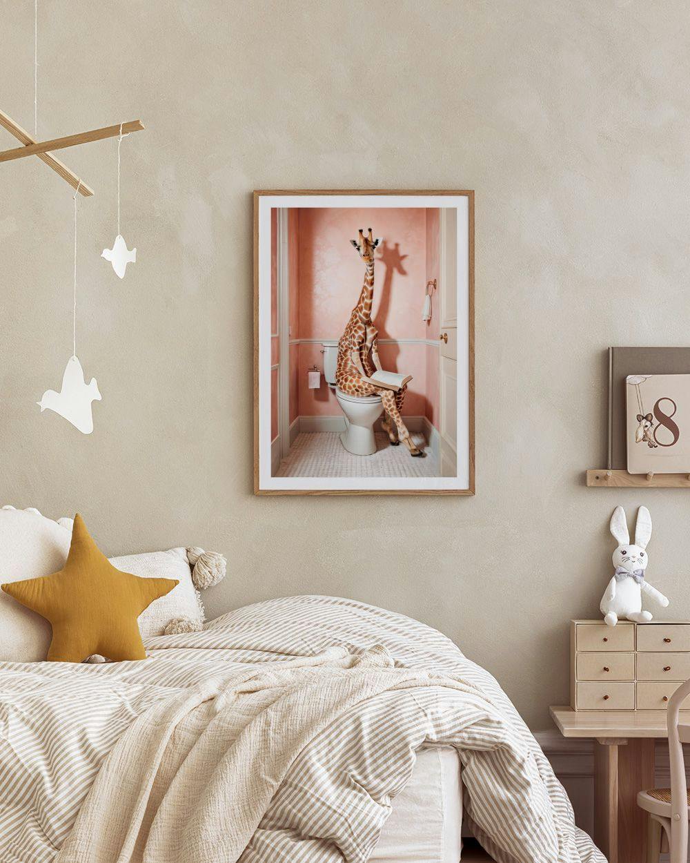Affiche humoristique dune girafe aux toilettes lisant un livre, suspendue dans une chambre denfant.