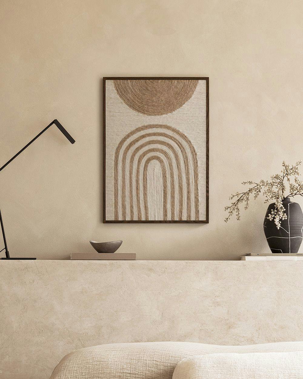 Affiche murale beige à motifs de cercle et darches, suspendue au-dessus dun canapé dans un salon moderne.