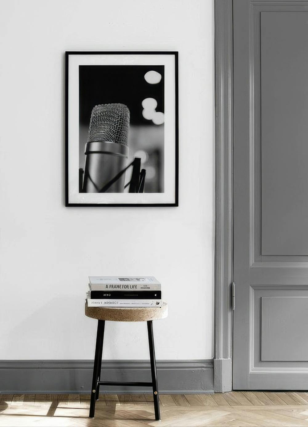 Affiche noire et blanche dun microphone de studio, accrochée dans une pièce aux murs blancs.