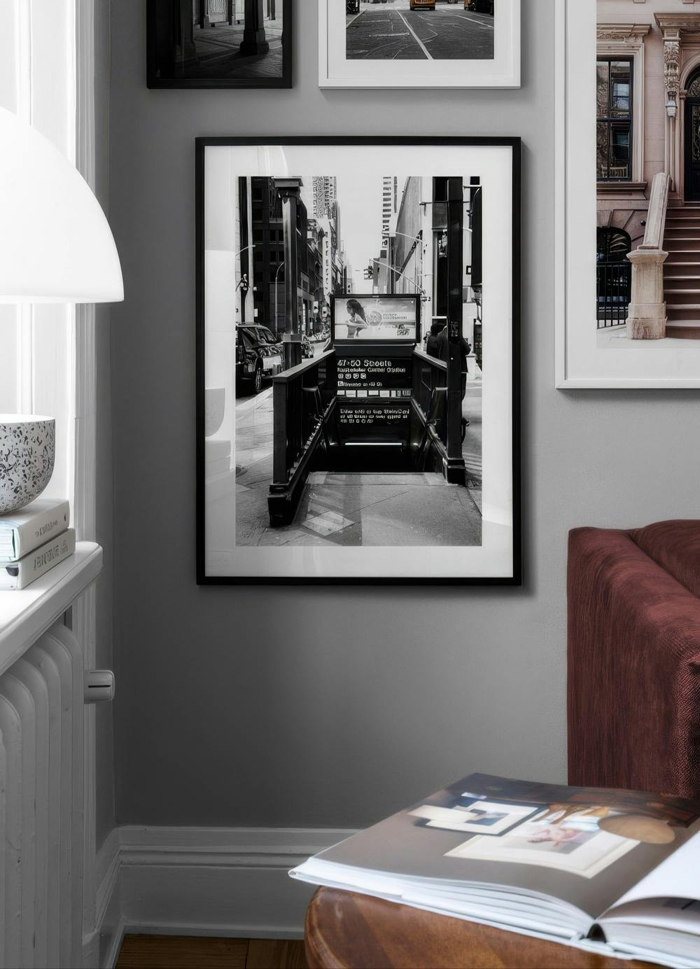 Affiche en noir et blanc dune entrée de métro à New York, affichée sur un mur gris dans un salon moderne.