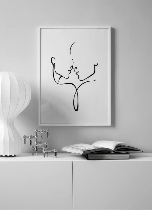Affiche minimaliste de deux visages de profil enlacés par une ligne noire, exposée dans un salon moderne.