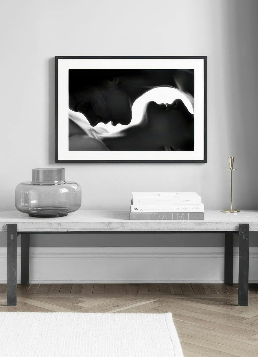 Affiche en noir et blanc de deux visages en profil, suspendue au-dessus dune table basse en béton dans un salon moderne.