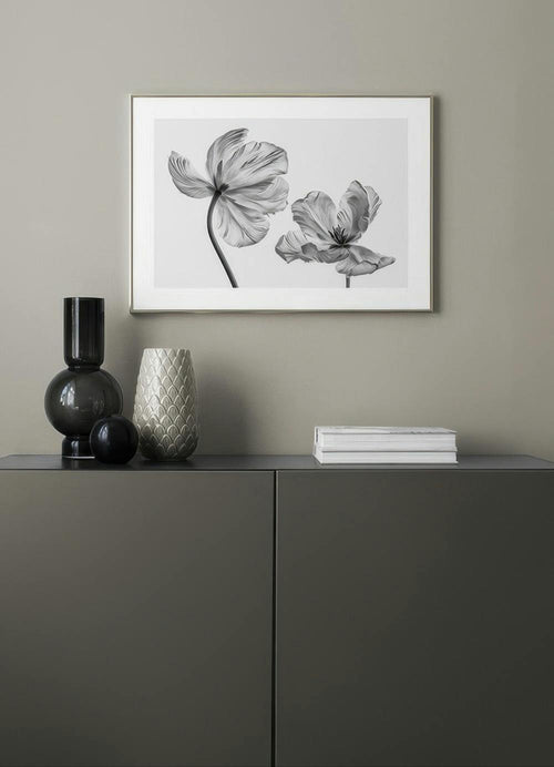 Affiche avec deux tulipes noir et blanc aux pétales ondulés, suspendue au-dessus dun buffet.