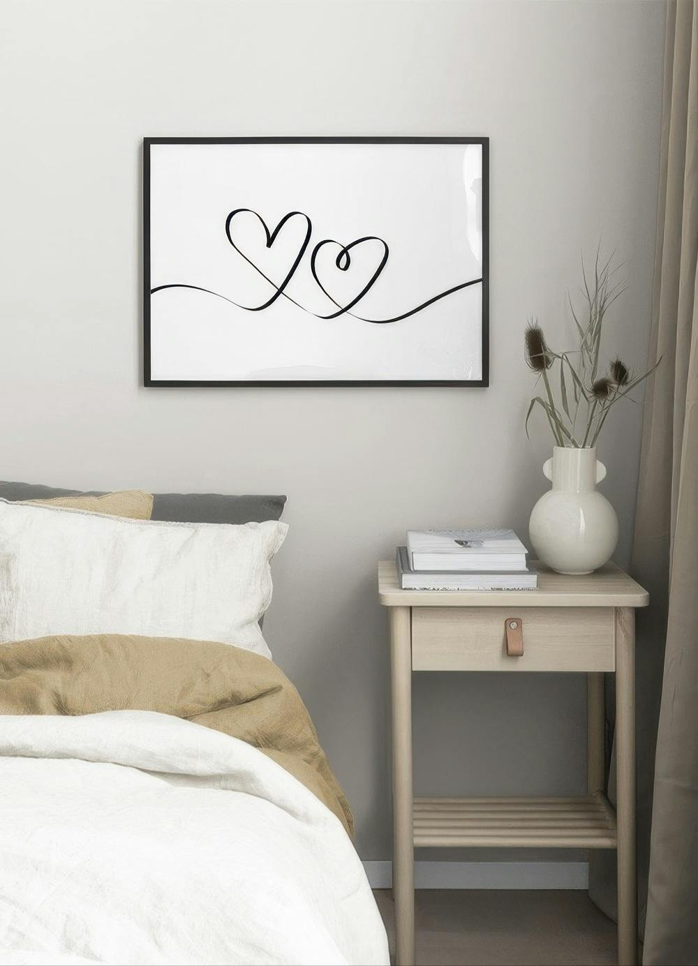 Affiche avec deux cœurs noirs entrelacés sur fond blanc, accrochée dans une chambre moderne au-dessus dun lit.