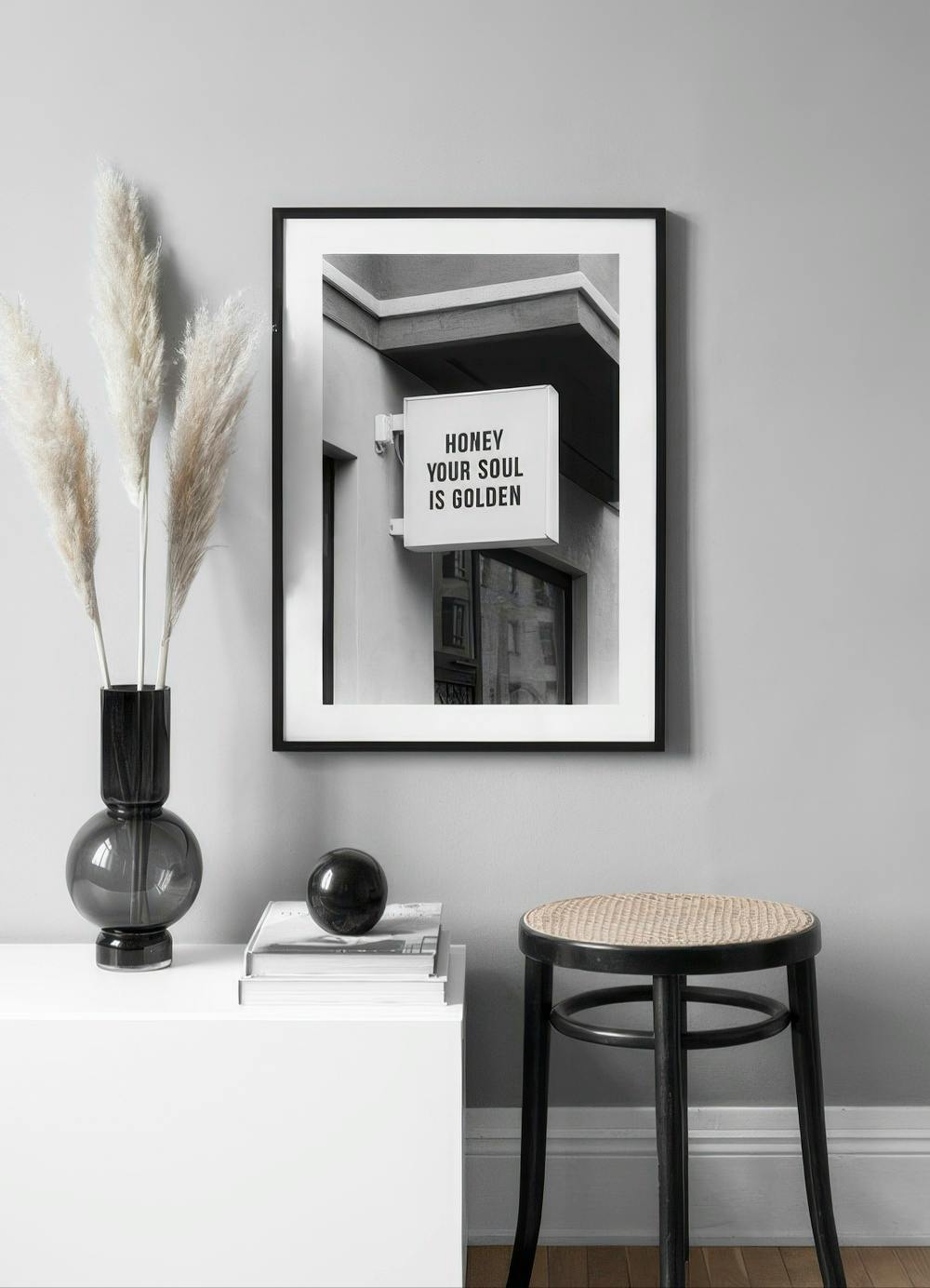 Affiche en noir et blanc dune enseigne HONEY YOUR SOUL IS GOLDEN dans une pièce moderne.