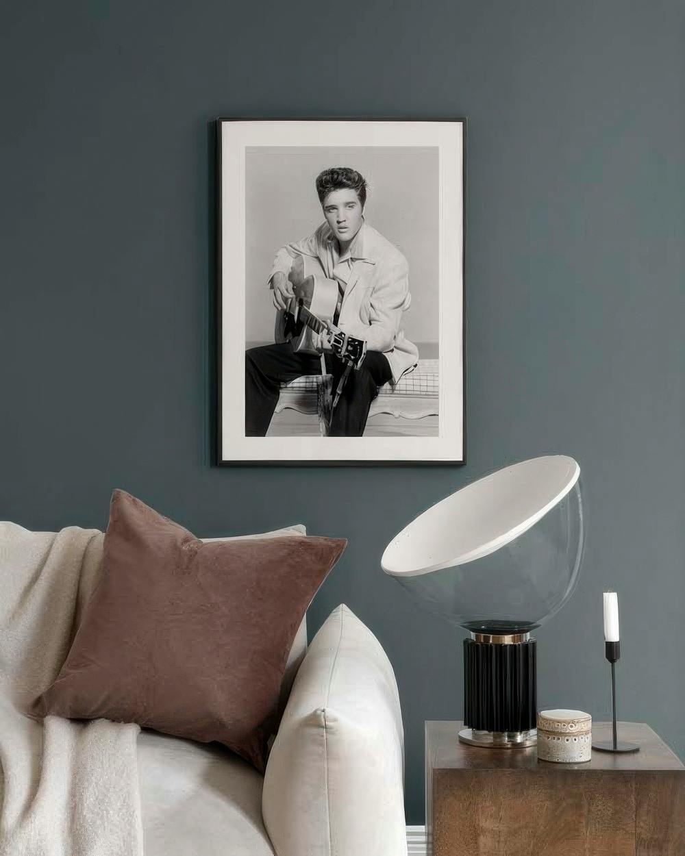 Affiche noir et blanc dElvis Presley avec sa guitare, suspendue au-dessus dun canapé dans un salon moderne.