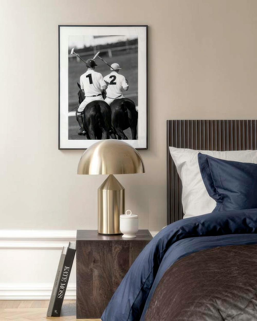 Affiche noir et blanc de joueurs de polo à cheval, suspendue dans une chambre moderne au-dessus dune table de chevet.