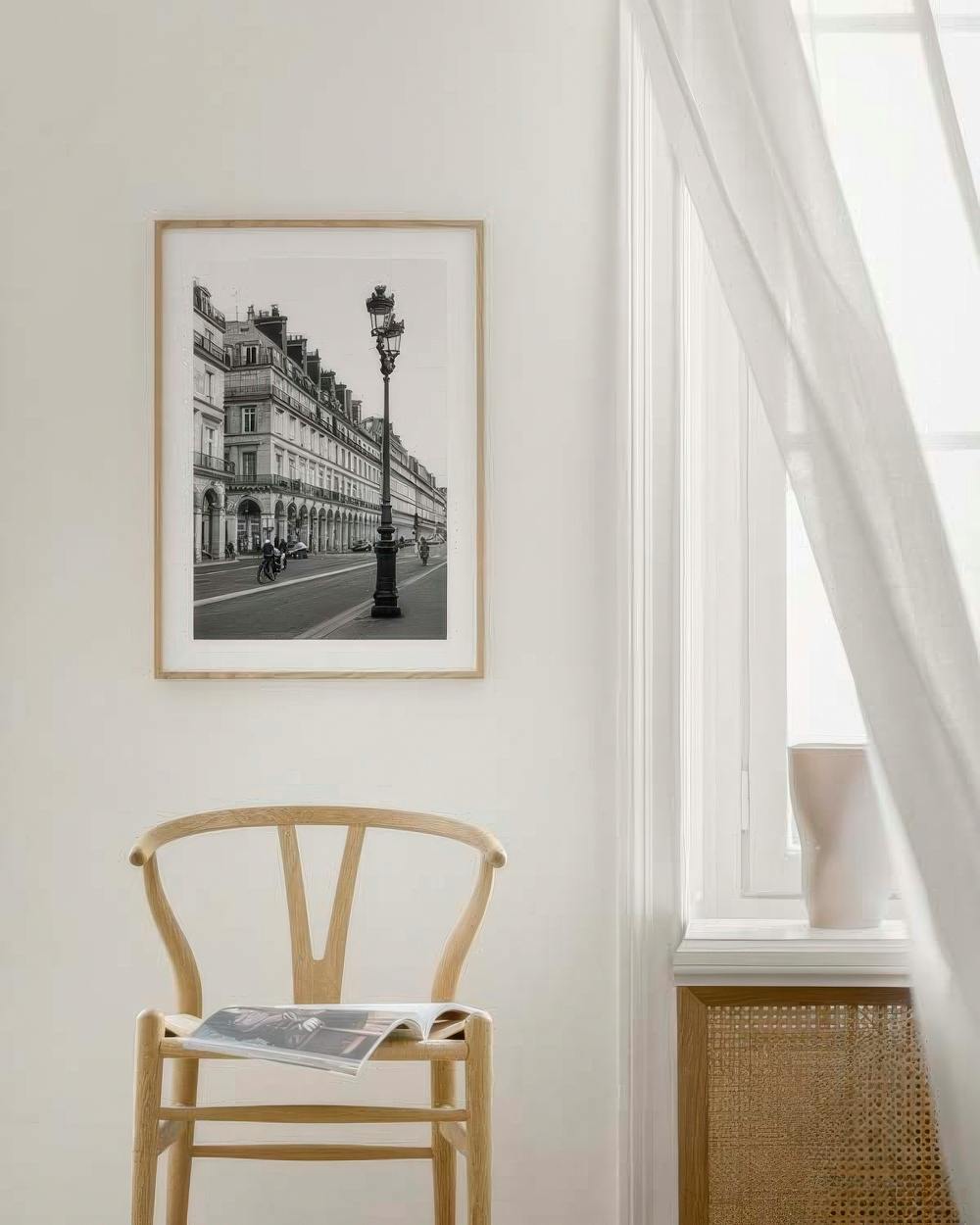 Affiche noir et blanc dune rue parisienne avec lampadaire, suspendue au-dessus dune chaise en bois.