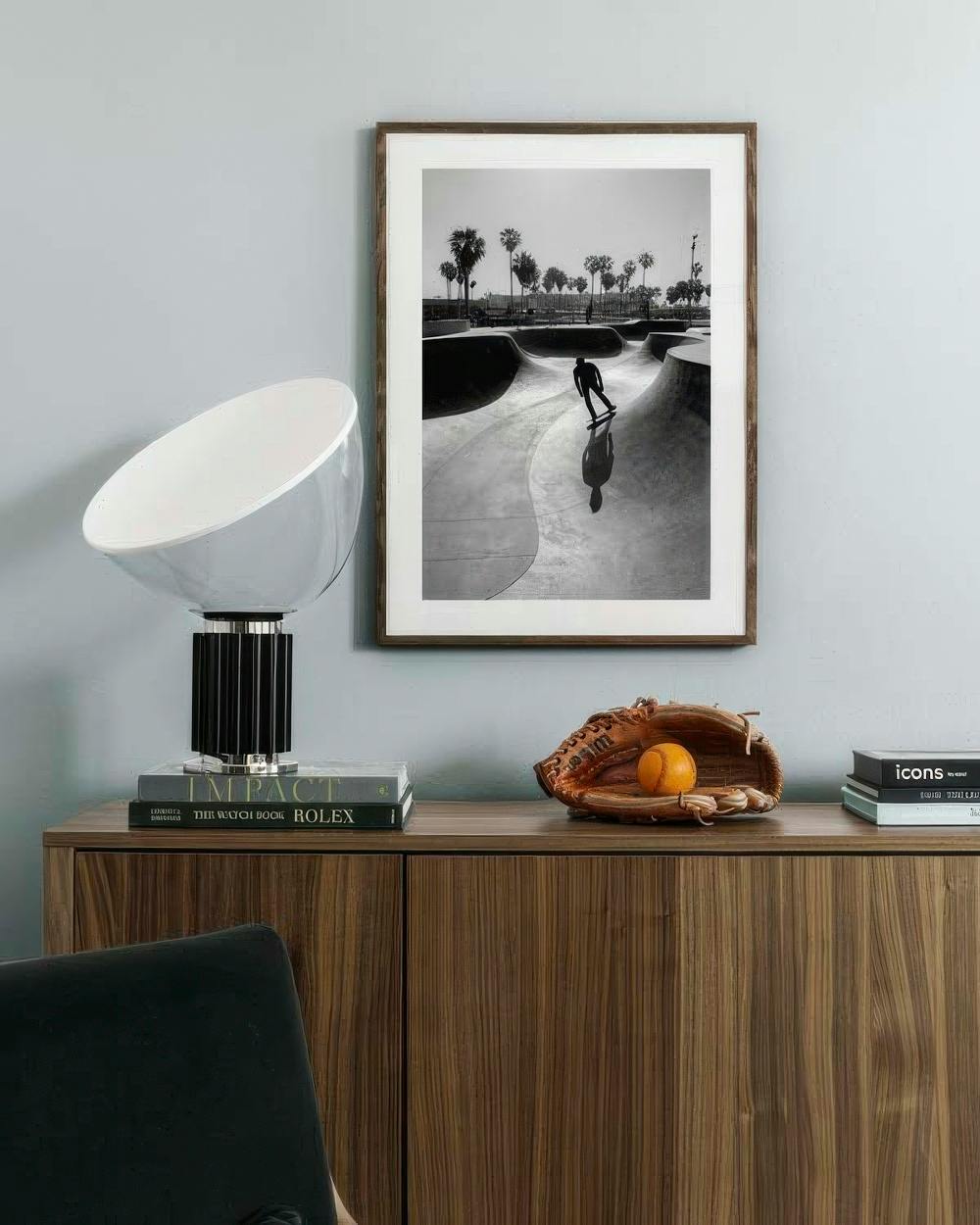 Affiche noir et blanc dun skateur dans un bowl, accrochée au mur au-dessus dun meuble en bois.