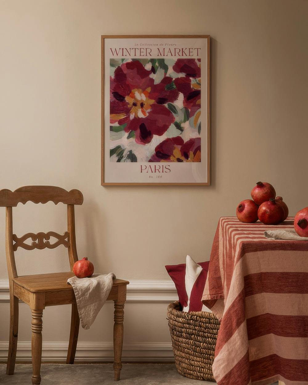 Affiche Winter Market Paris avec des fleurs rouges et roses, accrochée dans un intérieur chaleureux avec chaise en bois et table