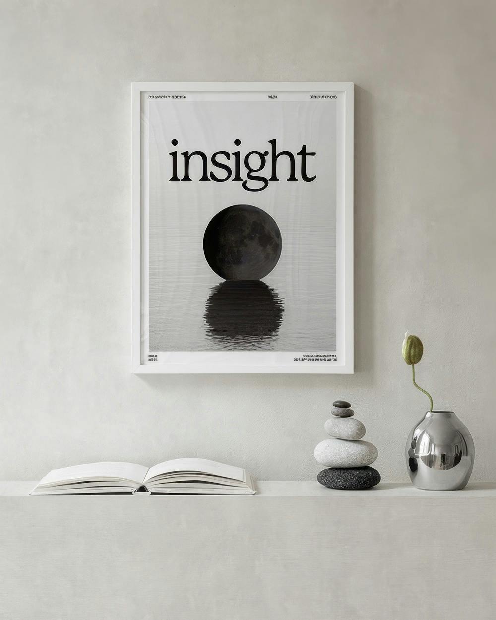 Affiche Insight minimaliste avec lune noire sur reflet deau, décorant un mur gris au-dessus dune étagère avec livre et vase.
