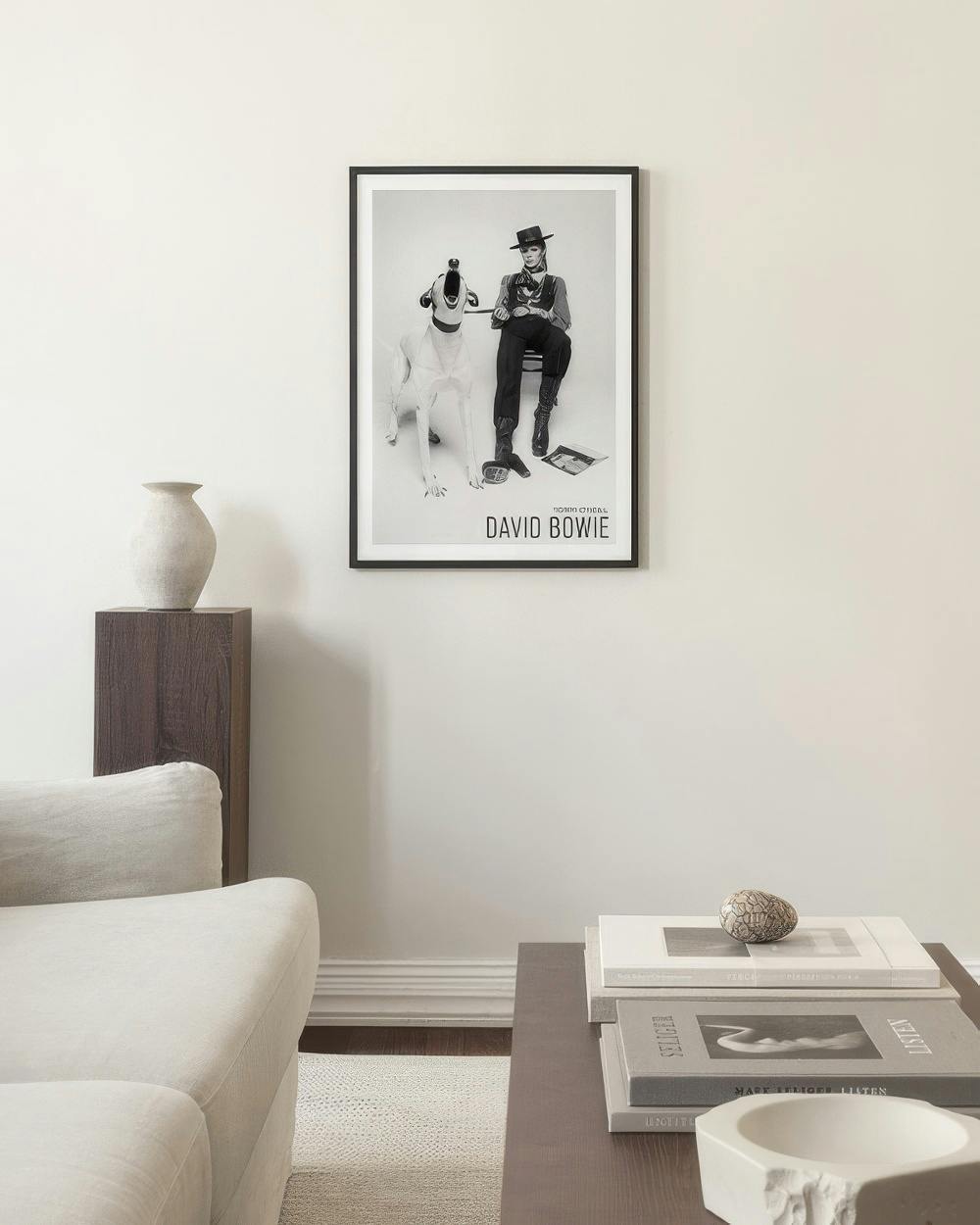 Affiche noir et blanc de David Bowie avec un chien, au-dessus dun canapé dans un salon moderne.