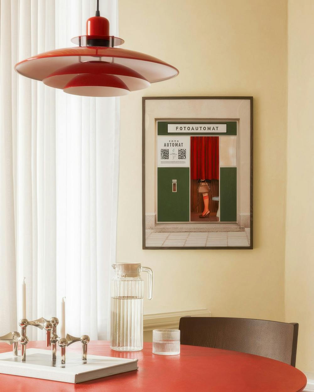 Affiche dun photomaton vert avec un rideau rouge et une personne en bas, dans une salle à manger lumineuse.