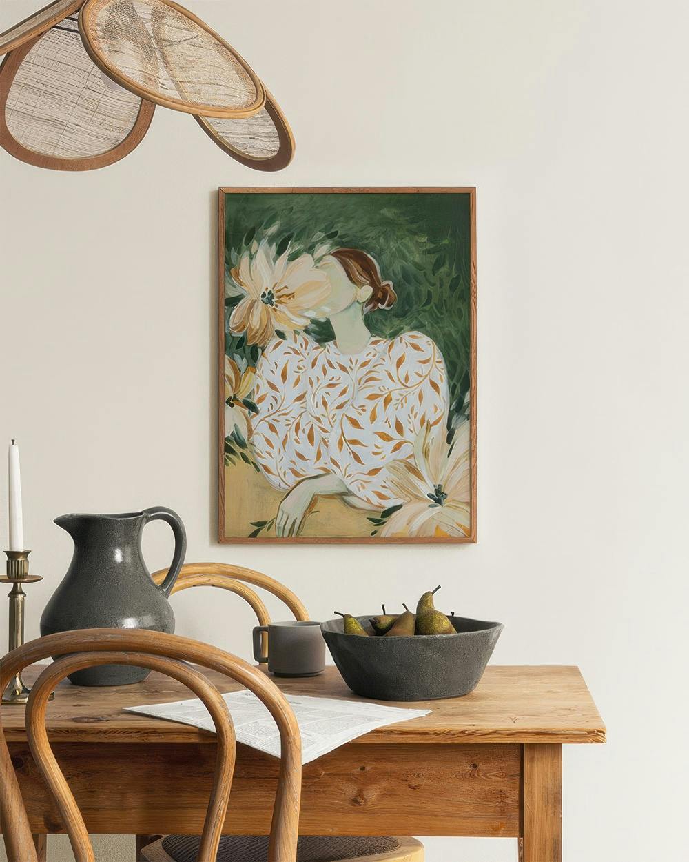 Affiche dune femme fleurie sur fond vert, suspendue au-dessus dune table en bois avec fruits et carafe.