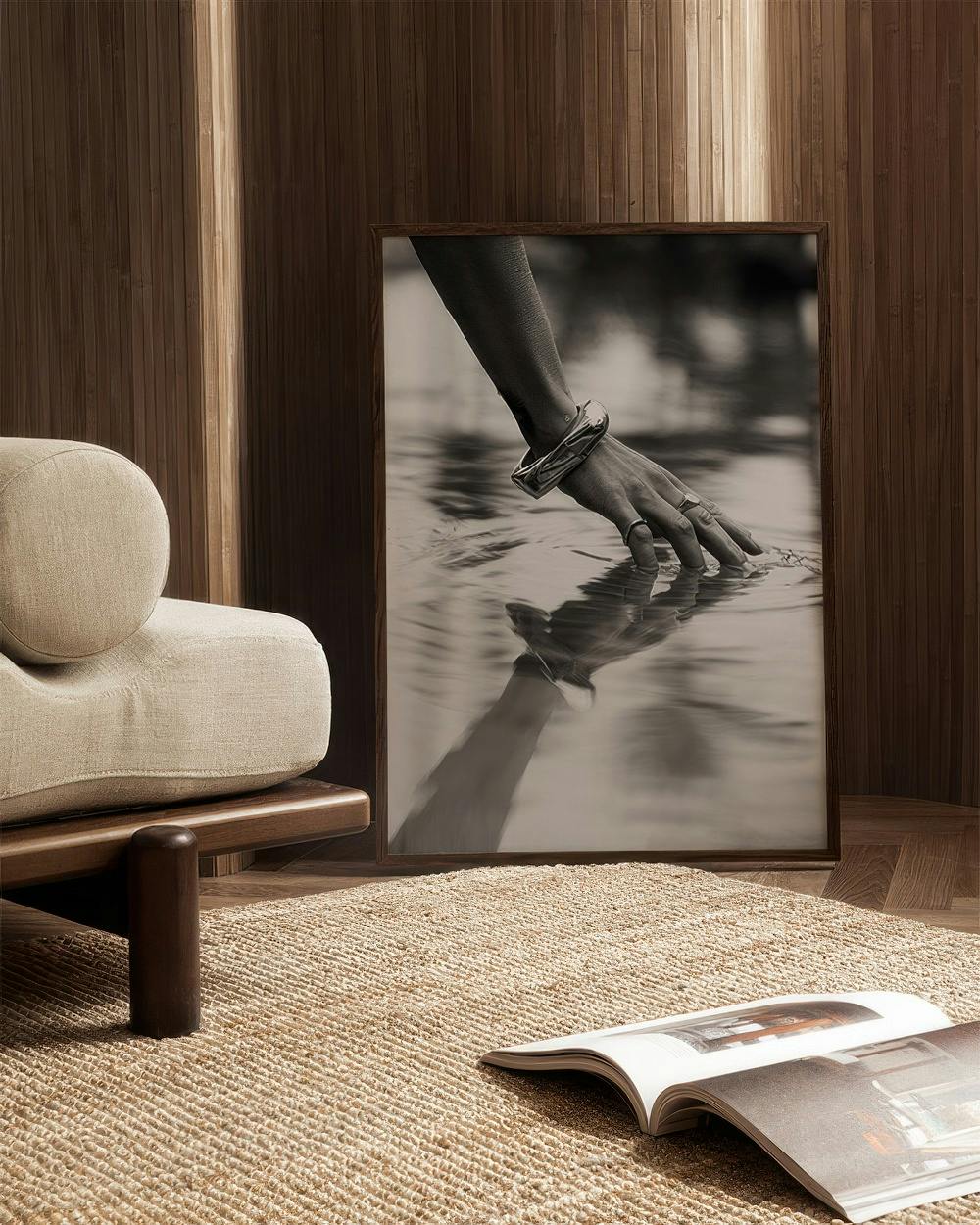 Affiche en noir et blanc dune main avec bracelets effleurant leau, dans un salon moderne.