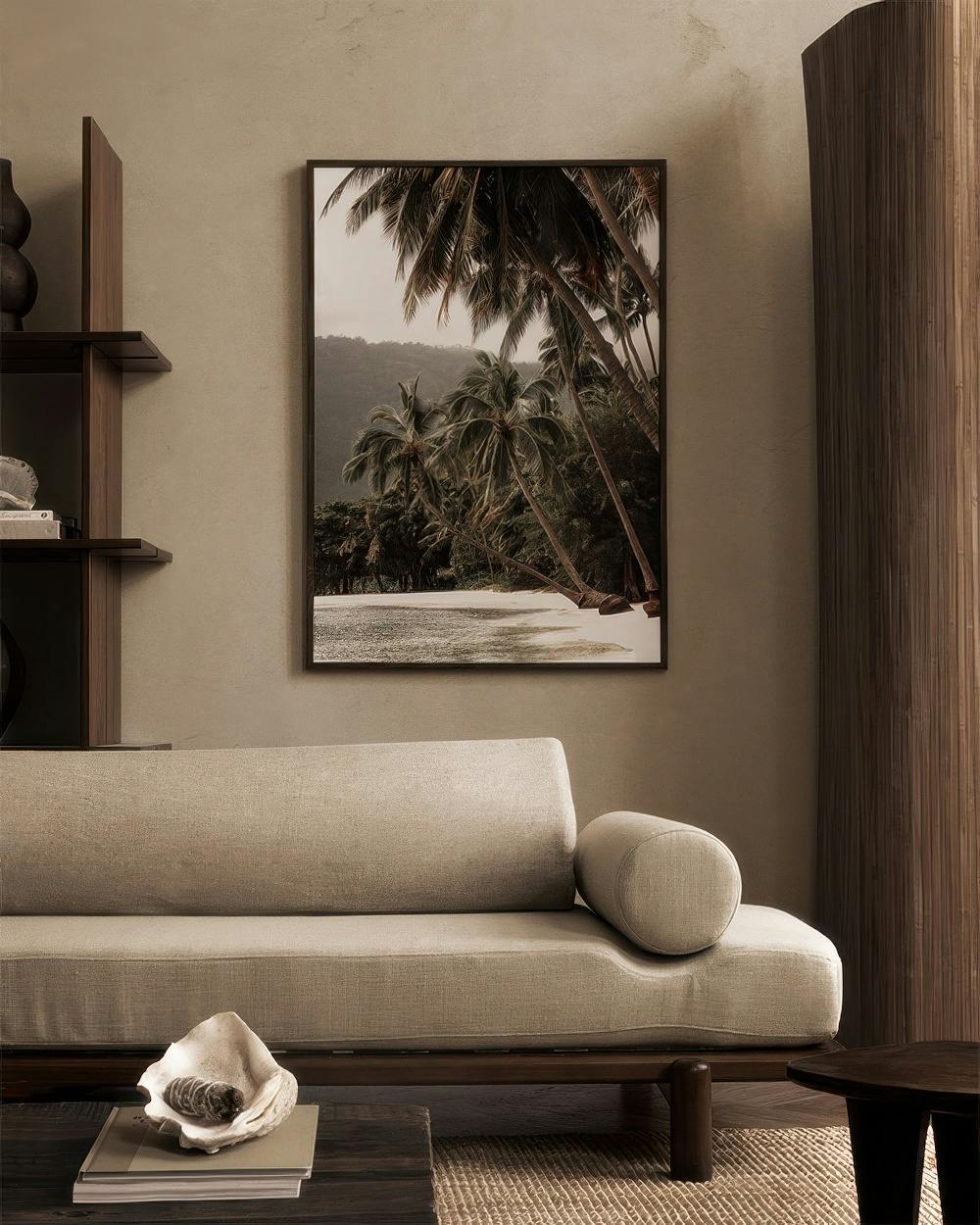 Affiche de plage tropicale avec des palmiers et du sable blanc, accrochée au-dessus dun canapé beige dans un salon moderne.