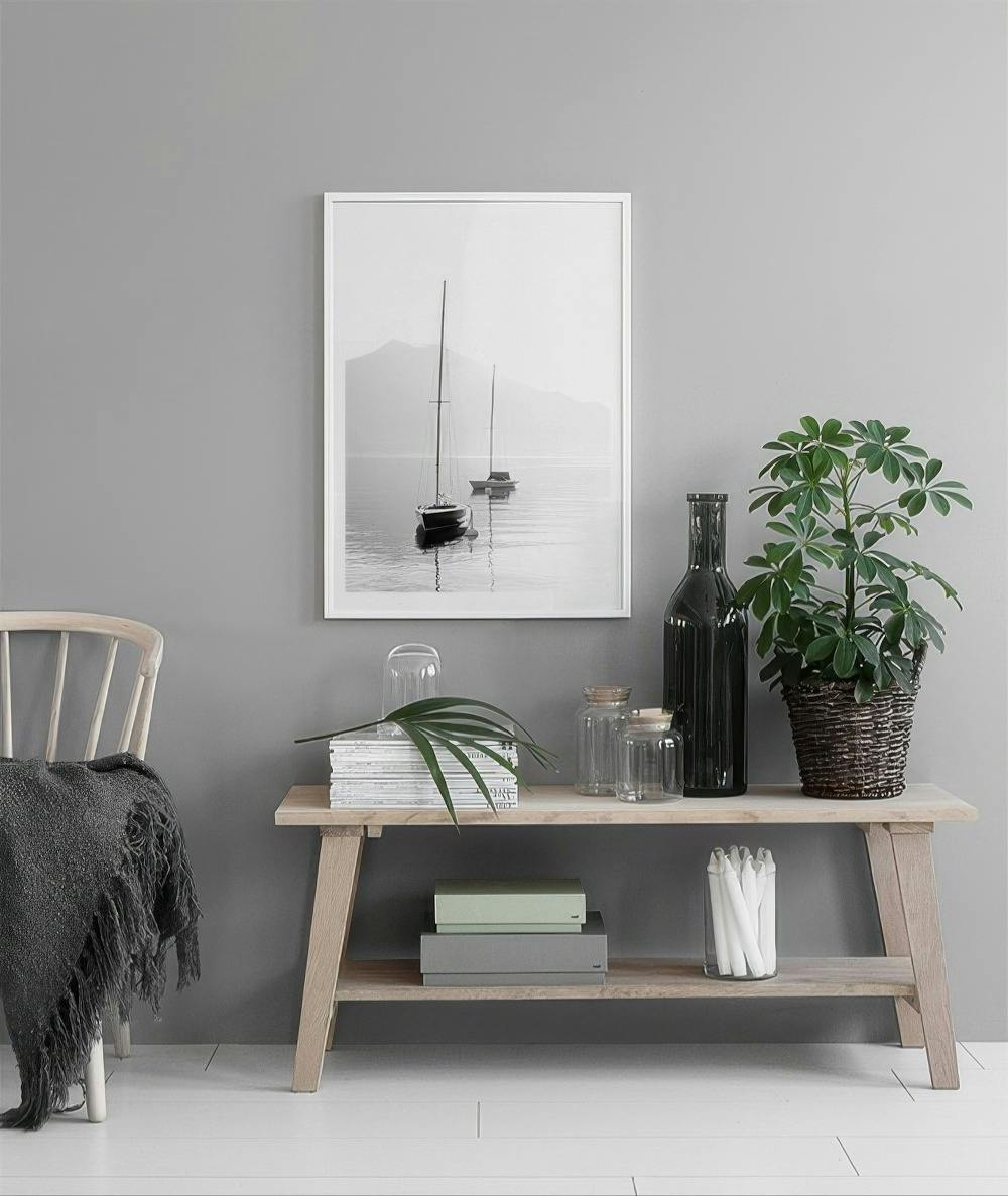 Affiche en noir et blanc de voiliers sur un lac brumeux, affichée dans un salon moderne.
