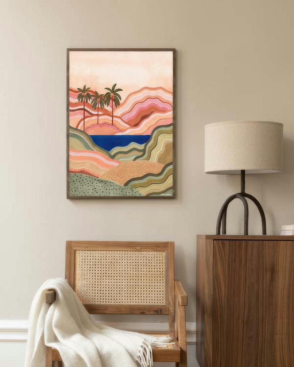 Affiche dun paysage abstrait avec palmiers et mer bleue, suspendue au-dessus dune chaise en bois dans un salon.