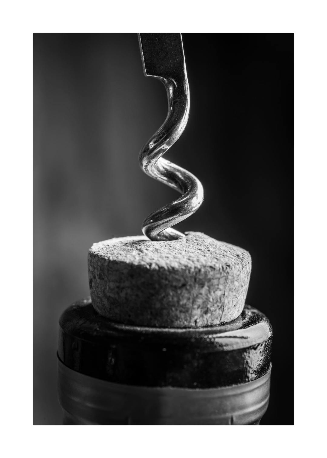 Affiche noir et blanc d un tire-bouchon métallique perçant un bouchon de liège sur une bouteille de vin
