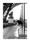 Affiche noir et blanc, femme avec parapluie marchant sous la Tour Eiffel à Paris, typographie élégante.