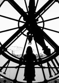 Affiche noir et blanc dune femme devant la grande horloge du Musée dOrsay, vue sur Paris, typographie en chiffres romains.