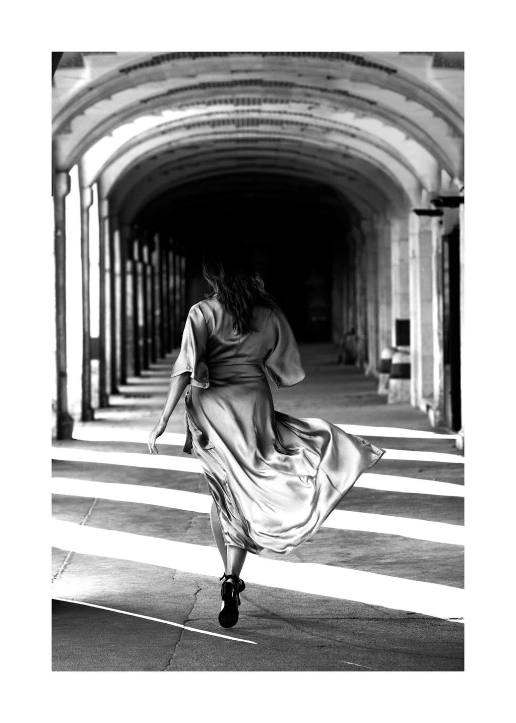 Affiche noir et blanc, femme en robe de soie courant sous des arcades, jeu de lumière, typographie parisienne.
