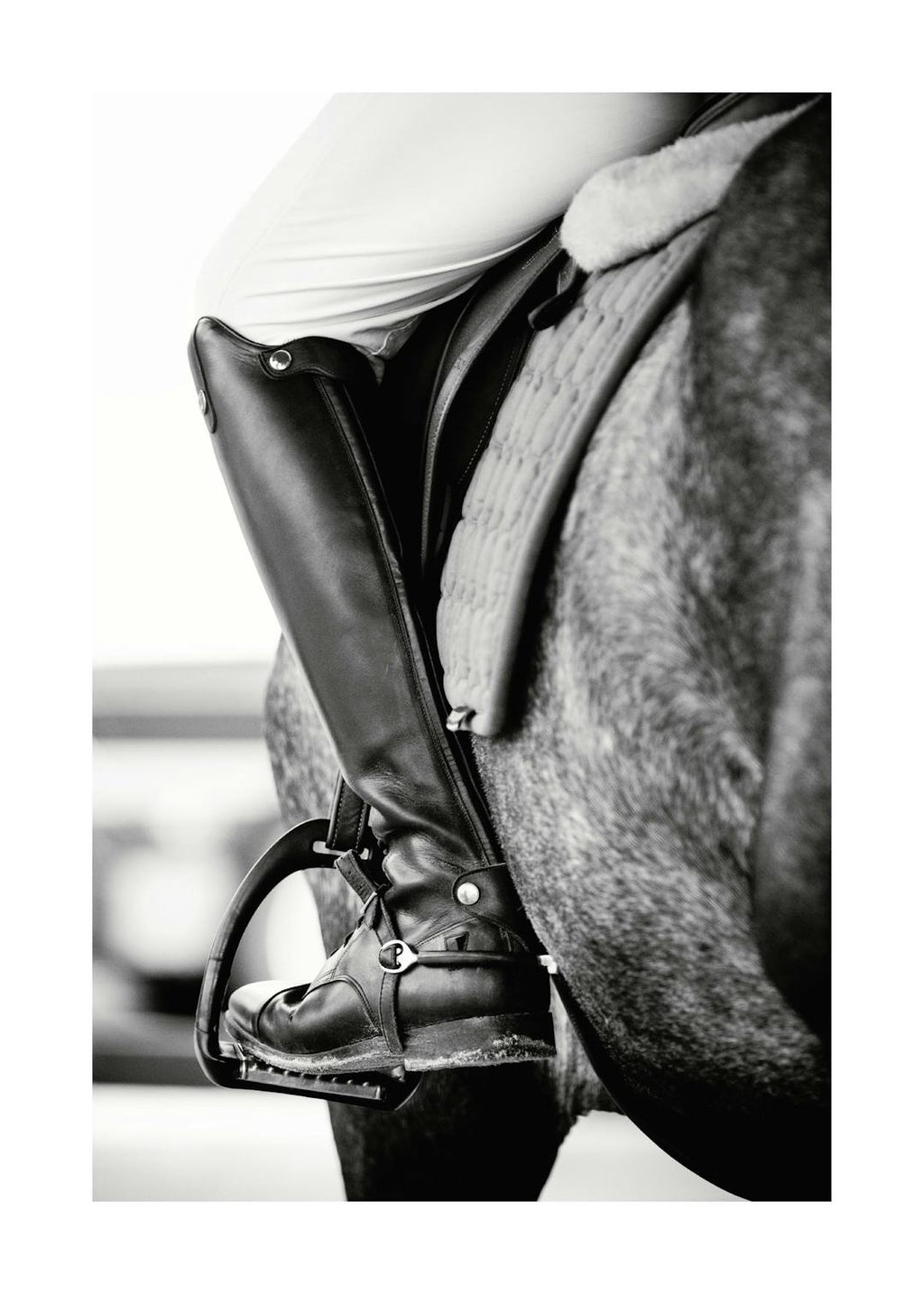 Affiche noir et blanc dune personne à cheval, focalisée sur la botte et létrier de léquitation.