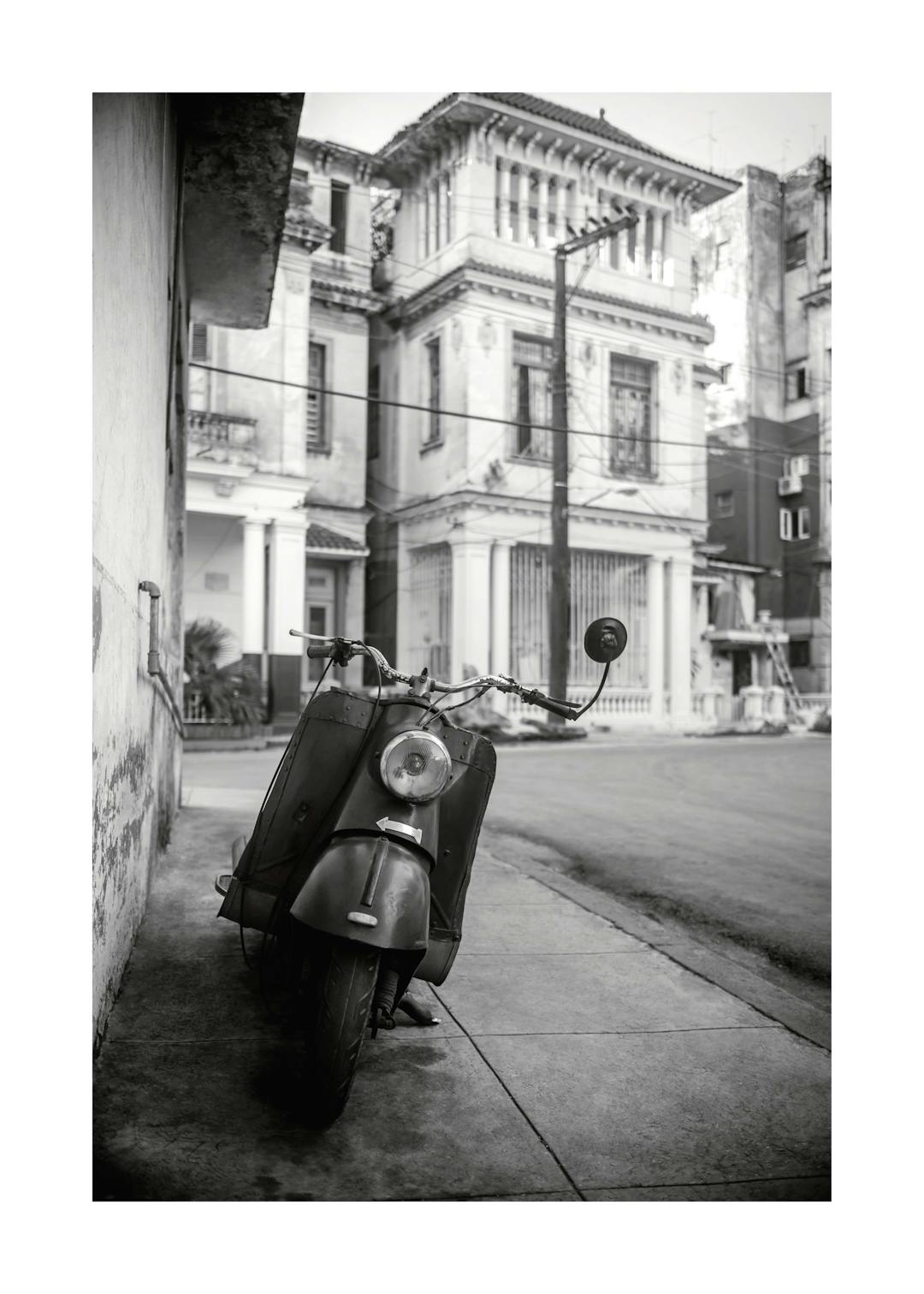 Affiche noir et blanc dune Vespa garée dans une rue de La Havane avec des bâtiments en arrière-plan