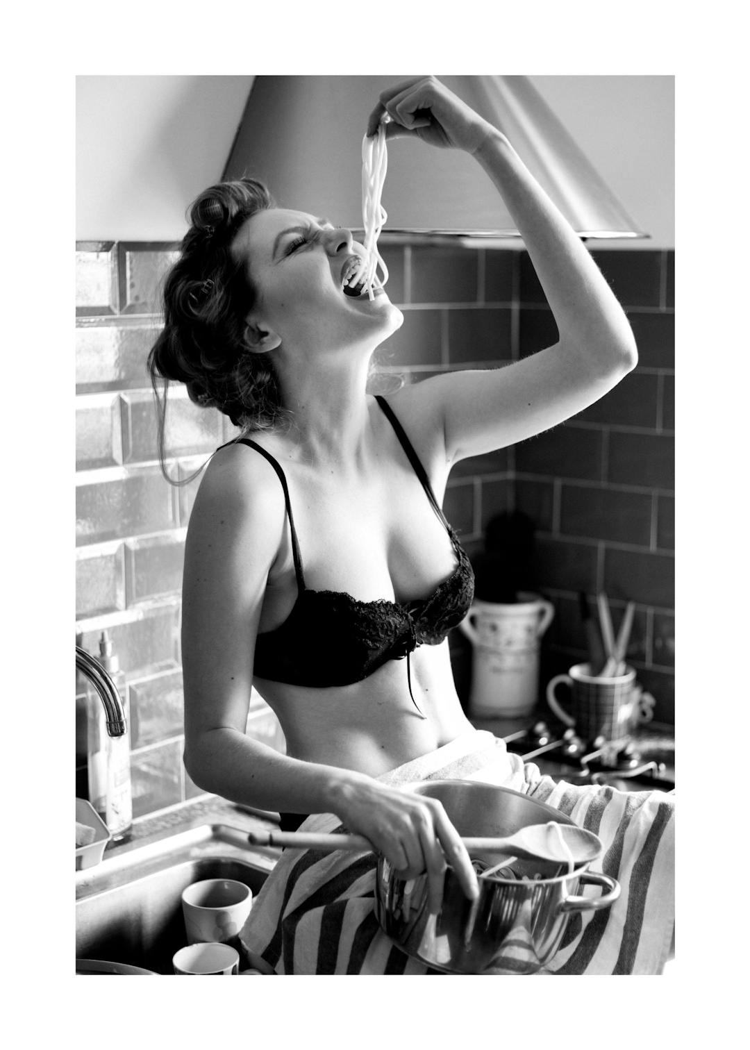 Affiche noir et blanc femme en soutien-gorge mangeant des pâtes dans une cuisine, style rétro