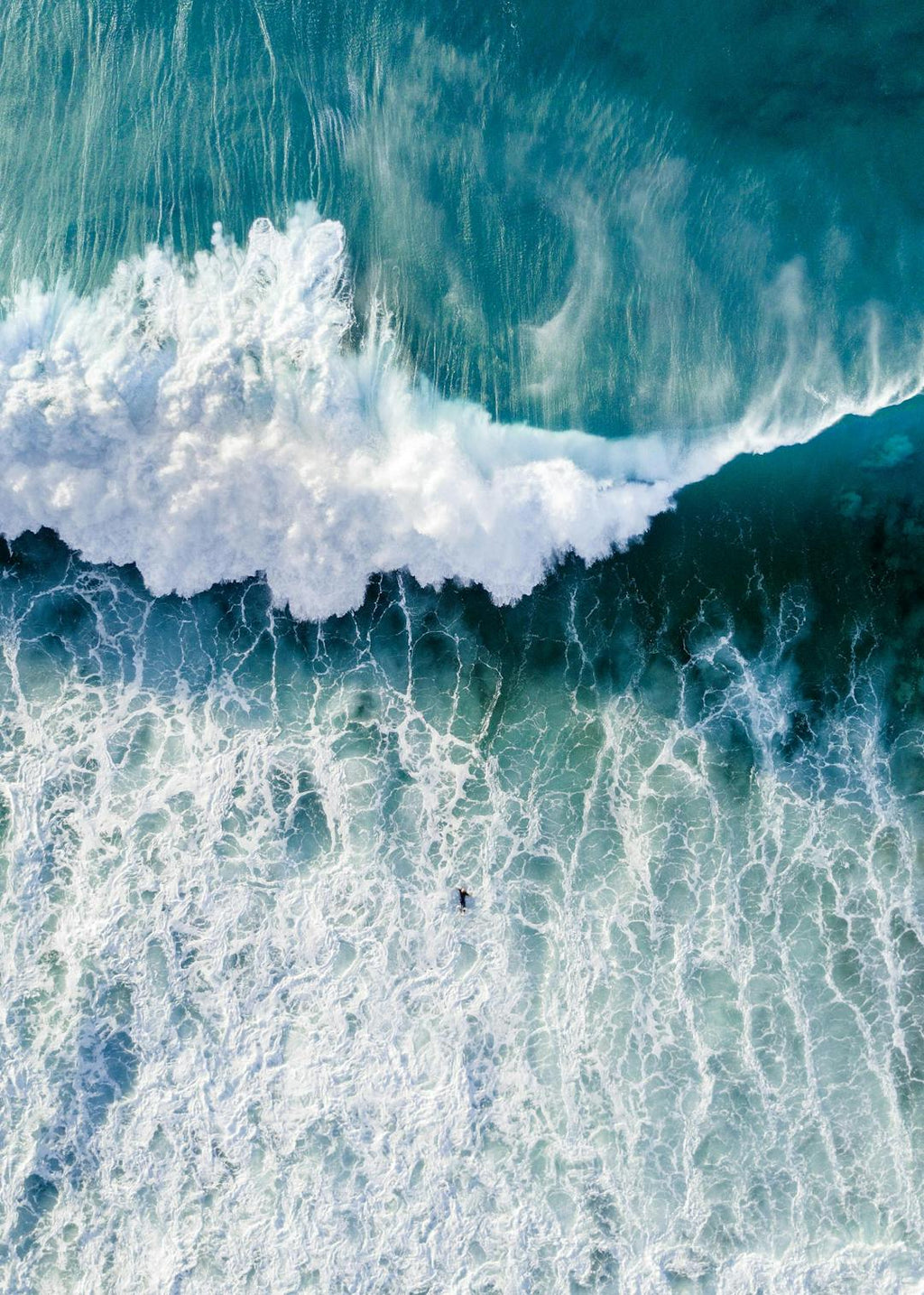 Affiche de locéan avec une grande vague turquoise et un surfeur, vue aérienne.