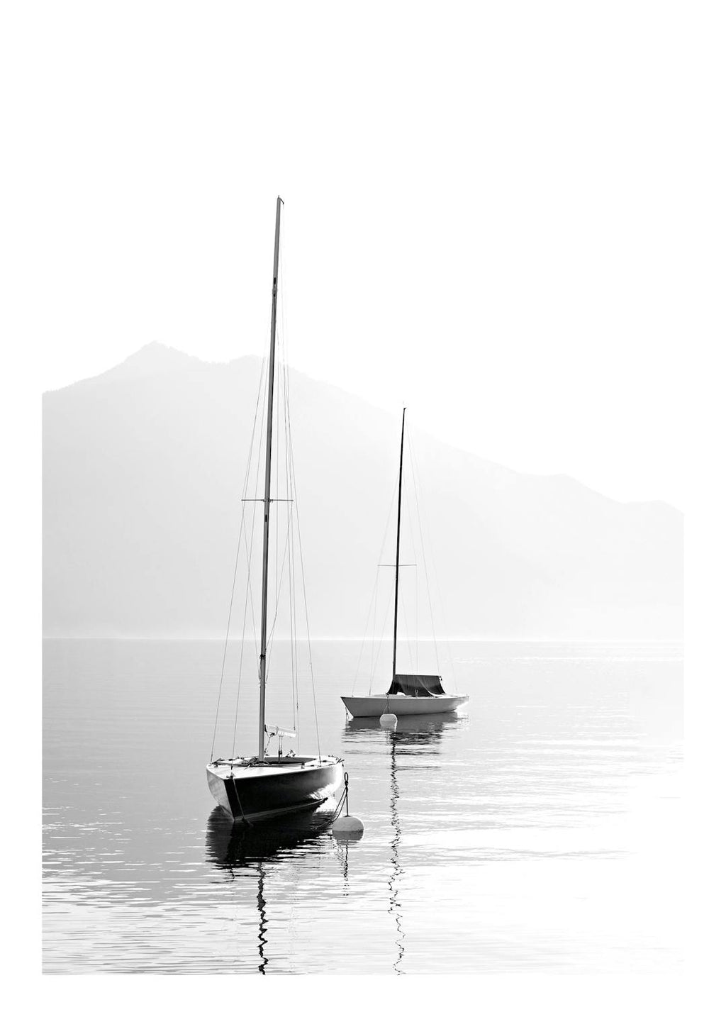 Affiche noir et blanc de deux voiliers sur une mer calme avec des montagnes en arrière-plan, reflétant la sérénité.