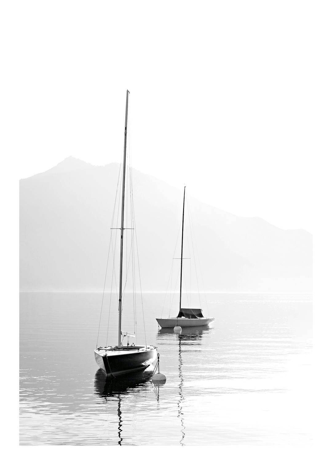 Affiche noir et blanc de deux voiliers sur une mer calme avec des montagnes en arrière-plan, reflétant la sérénité.