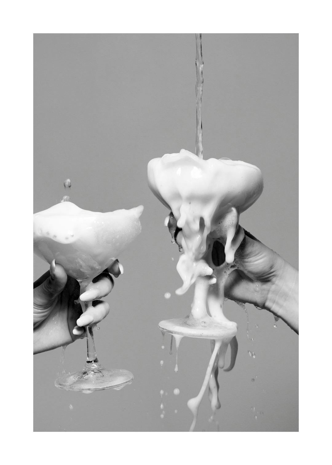 Affiche noir et blanc de deux mains tenant des coupes de champagne débordantes de mousse.