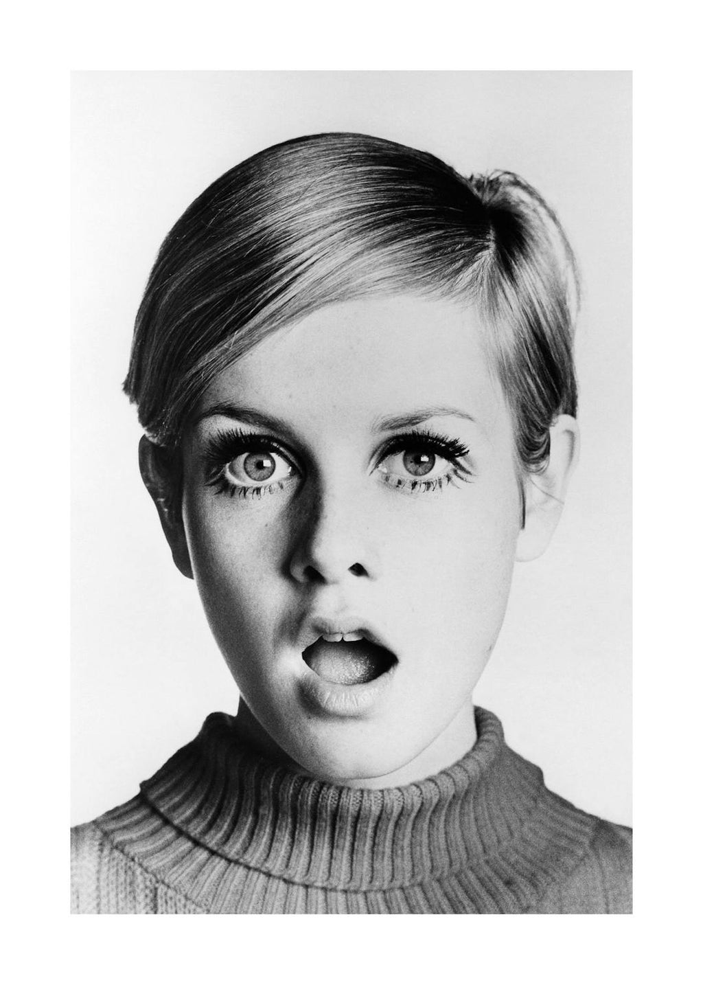 Affiche noir et blanc de Twiggy, icône de mode, avec un regard étonné et la bouche légèrement ouverte. Portrait vintage mettant 