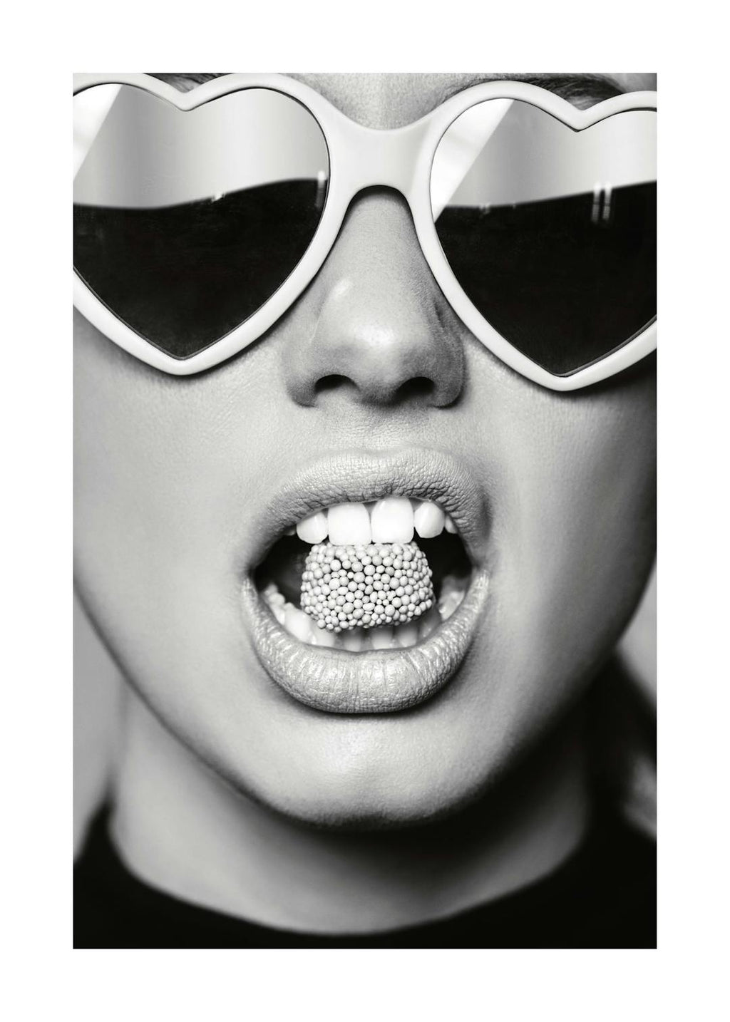 Affiche noir et blanc dun visage féminin avec des lunettes de soleil en forme de cœur et des bonbons dans la bouche, de style po