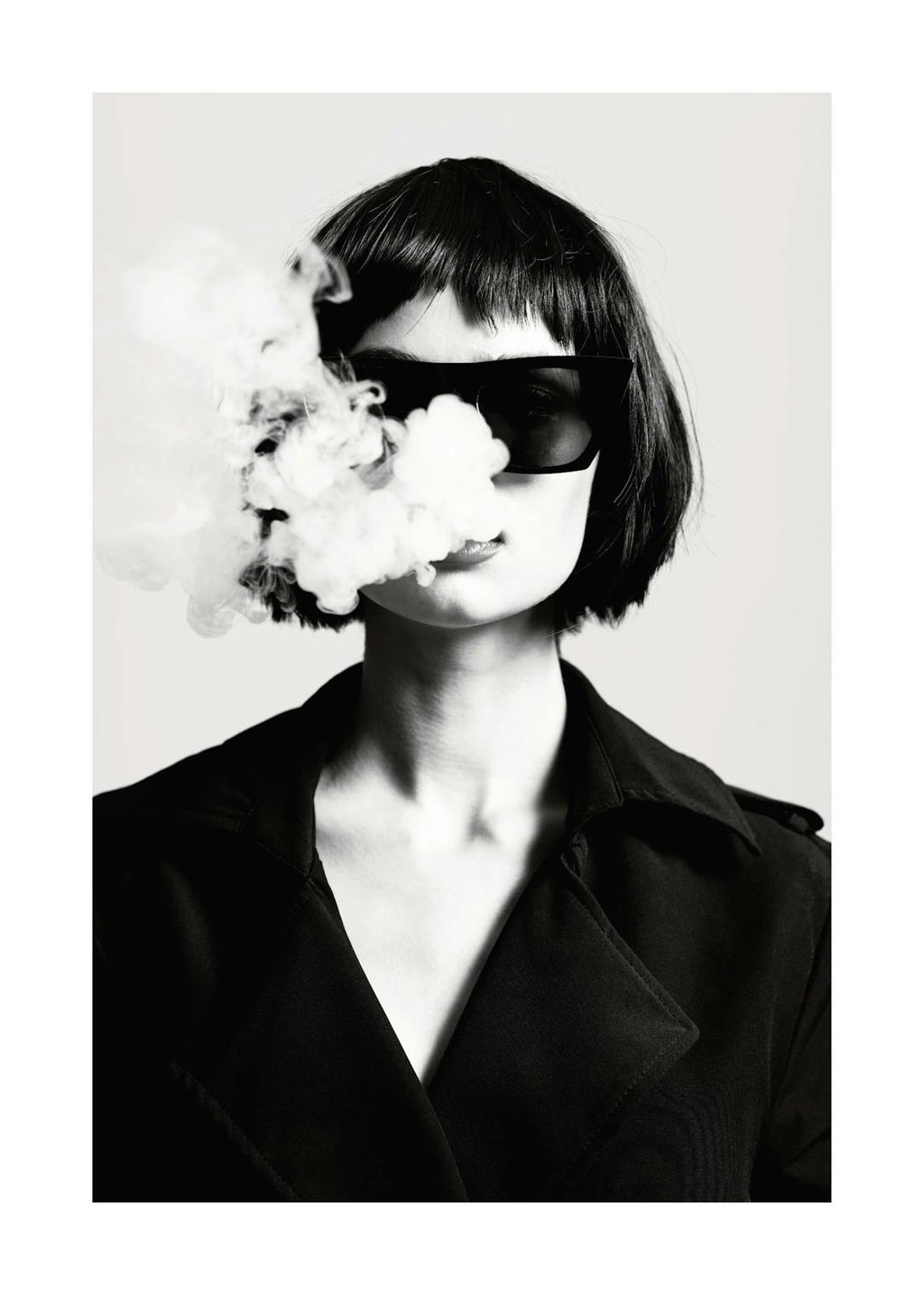 Affiche noir et blanc, femme aux cheveux courts et lunettes de soleil, fumée sortant de sa bouche. Photographie de mode