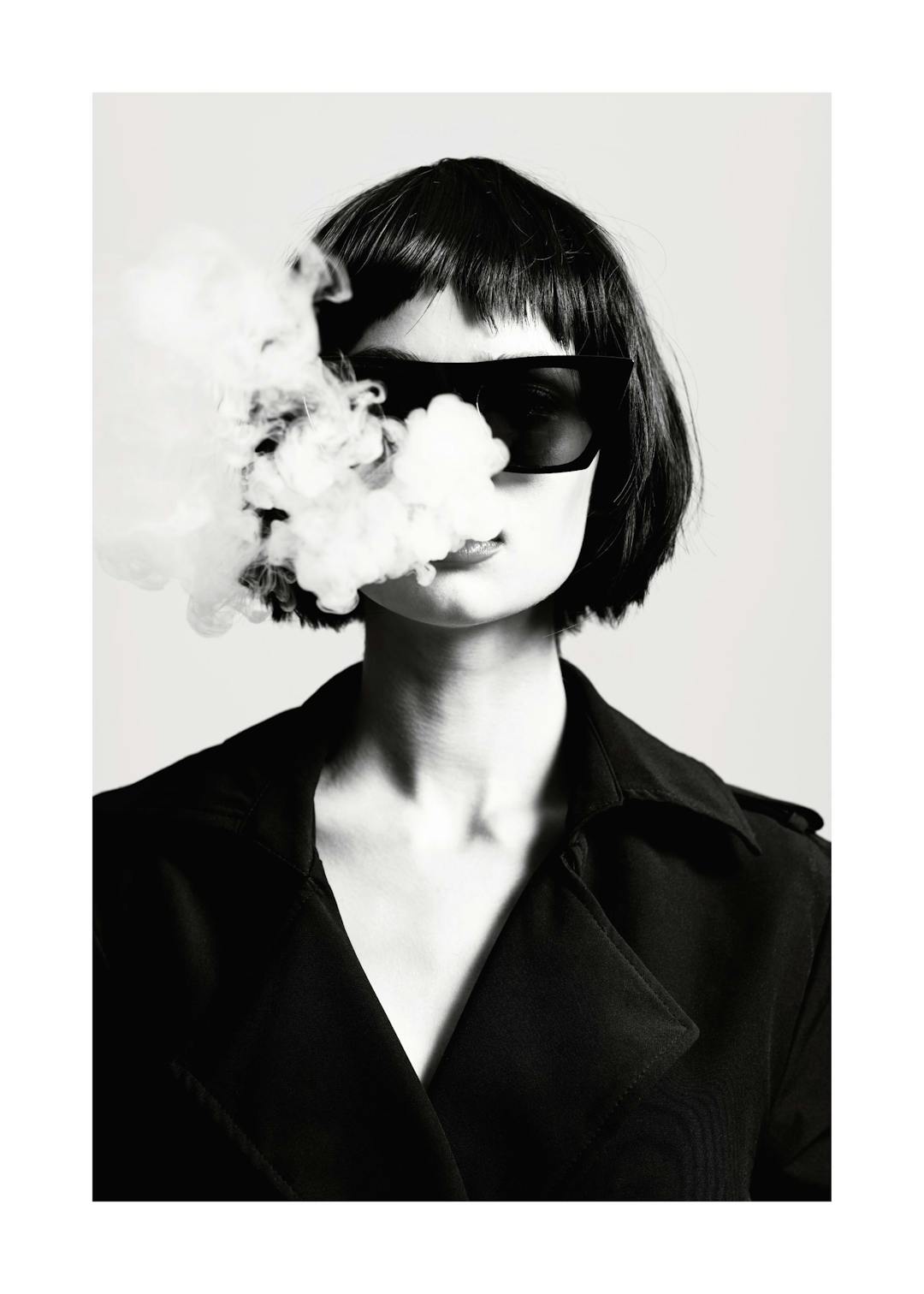 Affiche noir et blanc, femme aux cheveux courts et lunettes de soleil, fumée sortant de sa bouche. Photographie de mode
