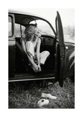 Affiche noir et blanc, femme assise dans une voiture ancienne, portière ouverte, chaussures dans lherbe