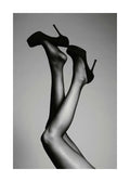 Affiche de photographie en noir et blanc de deux jambes tendues en lair avec des talons hauts noirs