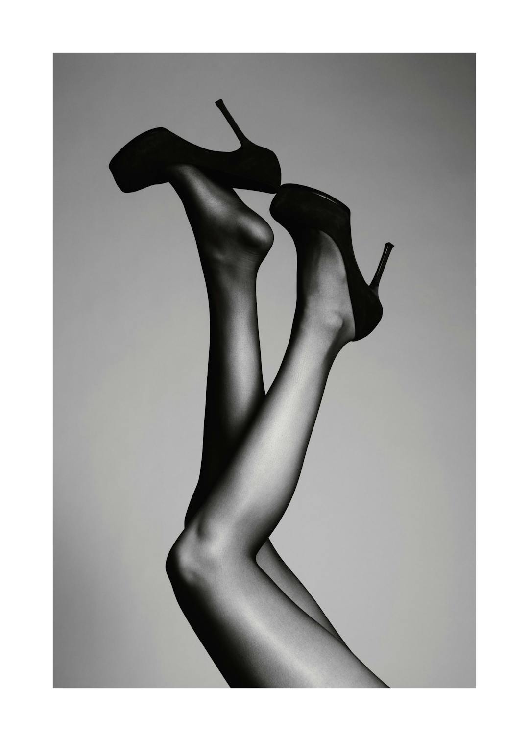 Affiche de photographie en noir et blanc de deux jambes tendues en lair avec des talons hauts noirs