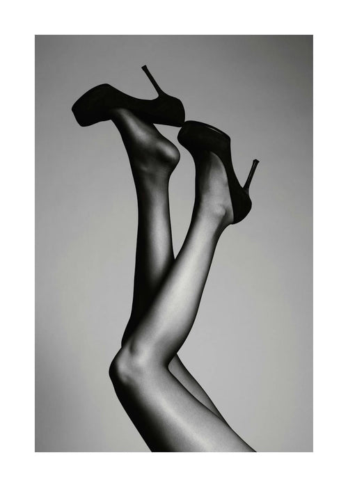 Affiche de photographie en noir et blanc de deux jambes tendues en lair avec des talons hauts noirs