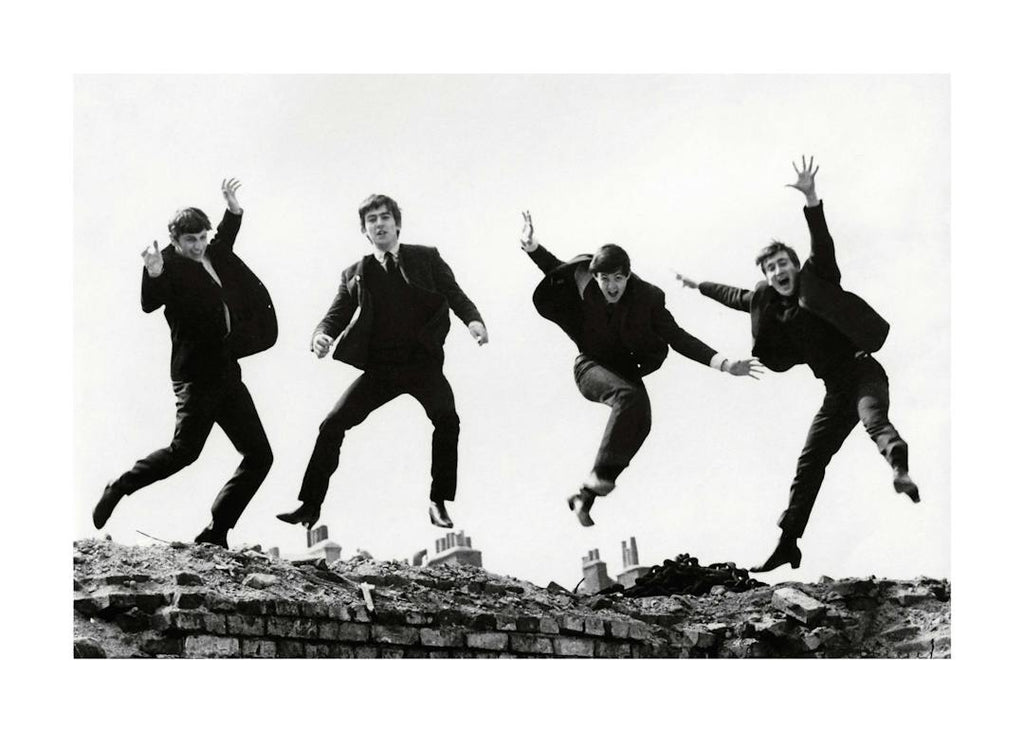 Affiche noir et blanc des Beatles sautant en lair, typographie granuleuse.