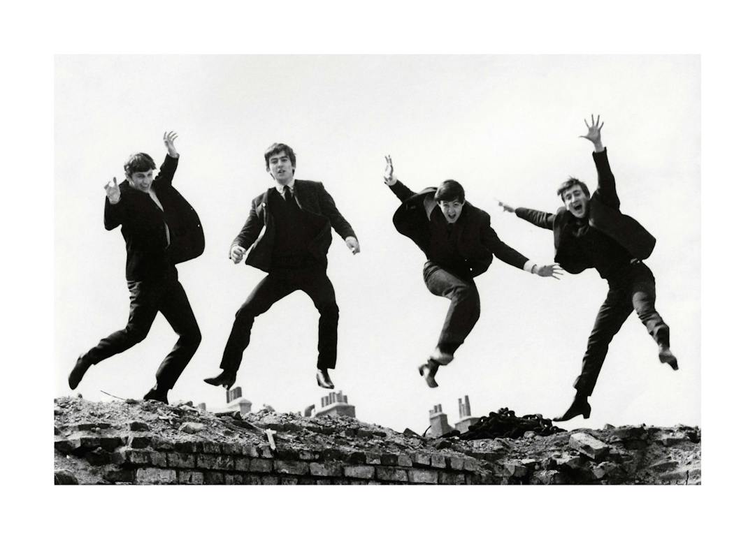 Affiche noir et blanc des Beatles sautant en lair, typographie granuleuse.