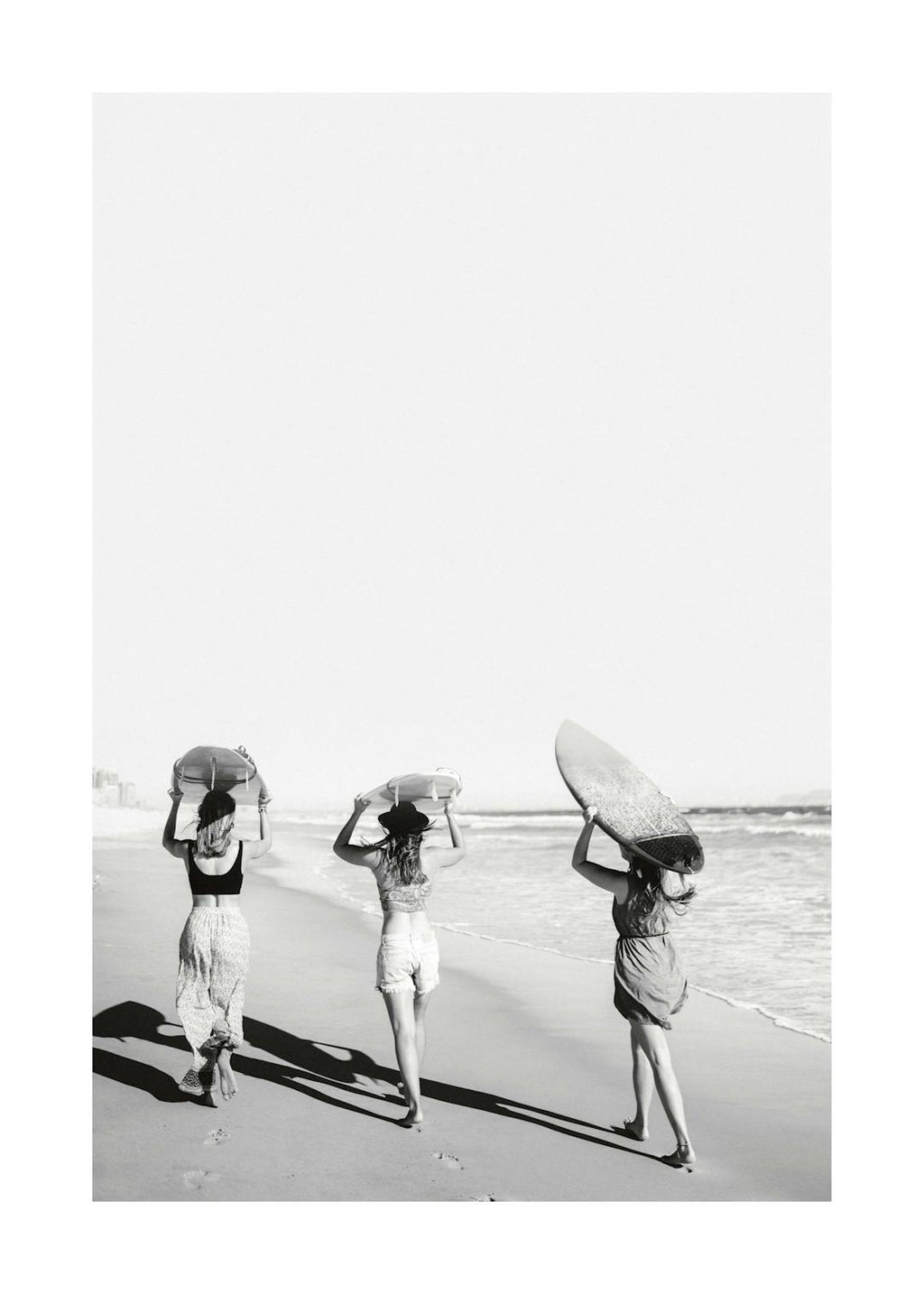 Affiche noir et blanc de trois filles tenant des planches de surf sur la plage