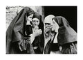 Affiche noir et blanc de quatre religieuses fumant, lune allumant la cigarette dune autre. Photographie iconique.