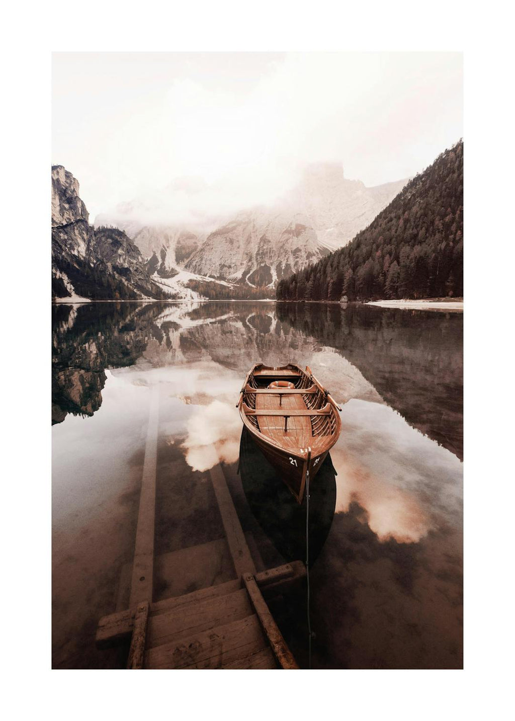 Affiche dun lac calme avec une barque en bois et des montagnes enneigées, reflétant le ciel nuageux