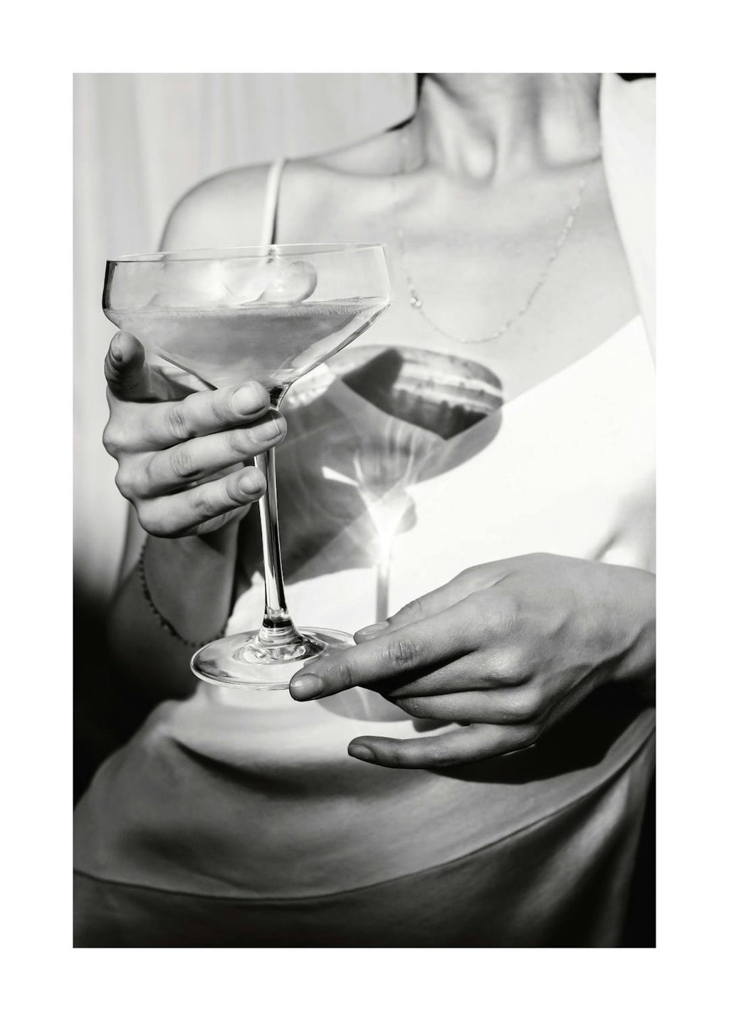 Affiche en noir et blanc dune femme tenant une coupe de champagne, style photographie classique.