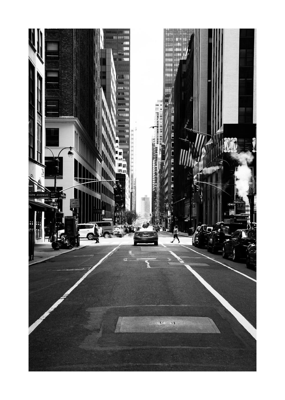 Affiche noir et blanc dune rue des États-Unis bordée de gratte-ciel et de voitures, avec un effet de fumée.